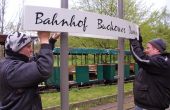 Parkbahnbetreiber Peter Erk (re) und Sohn Kevin bringen neue Bahnhofsschilder der Britzer Parkbahn an (Foto Hermann Schmidtendo